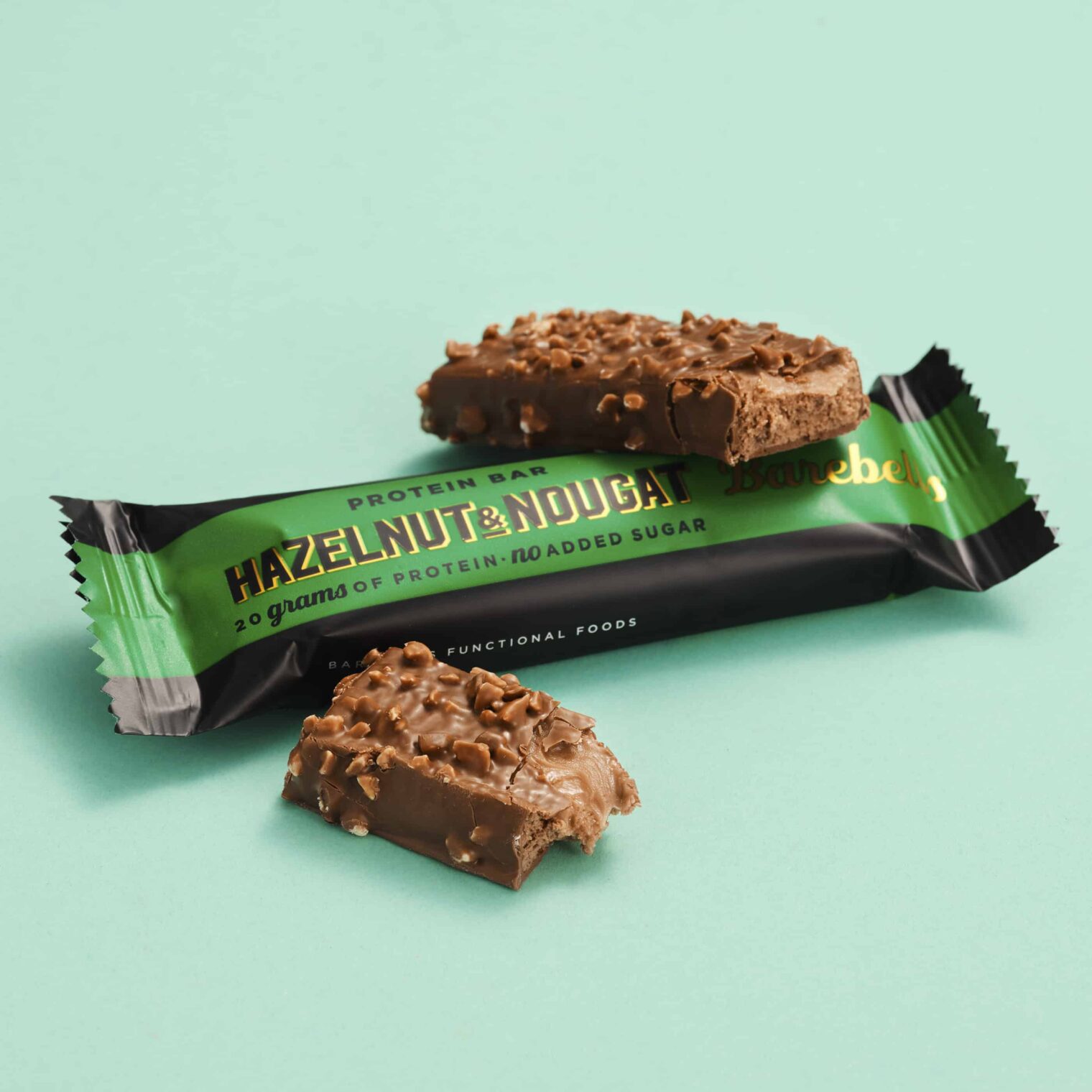Proteinriegel mit Haselnuss und Nugat auf türkisem Hintergrund.